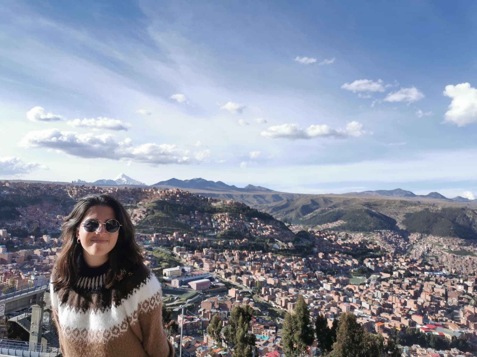 Maïlys, your travel planner, in front of the panorama of La Paz and the snow-capped summit of Illimani