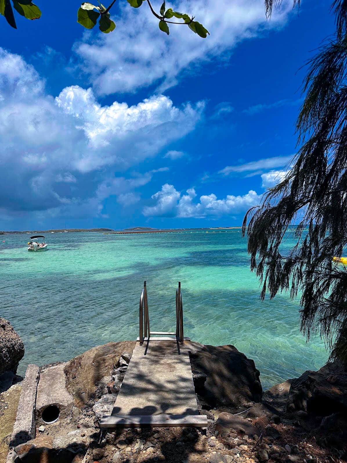 Pontoon over translucent turquoise water in a secluded Martinique cove