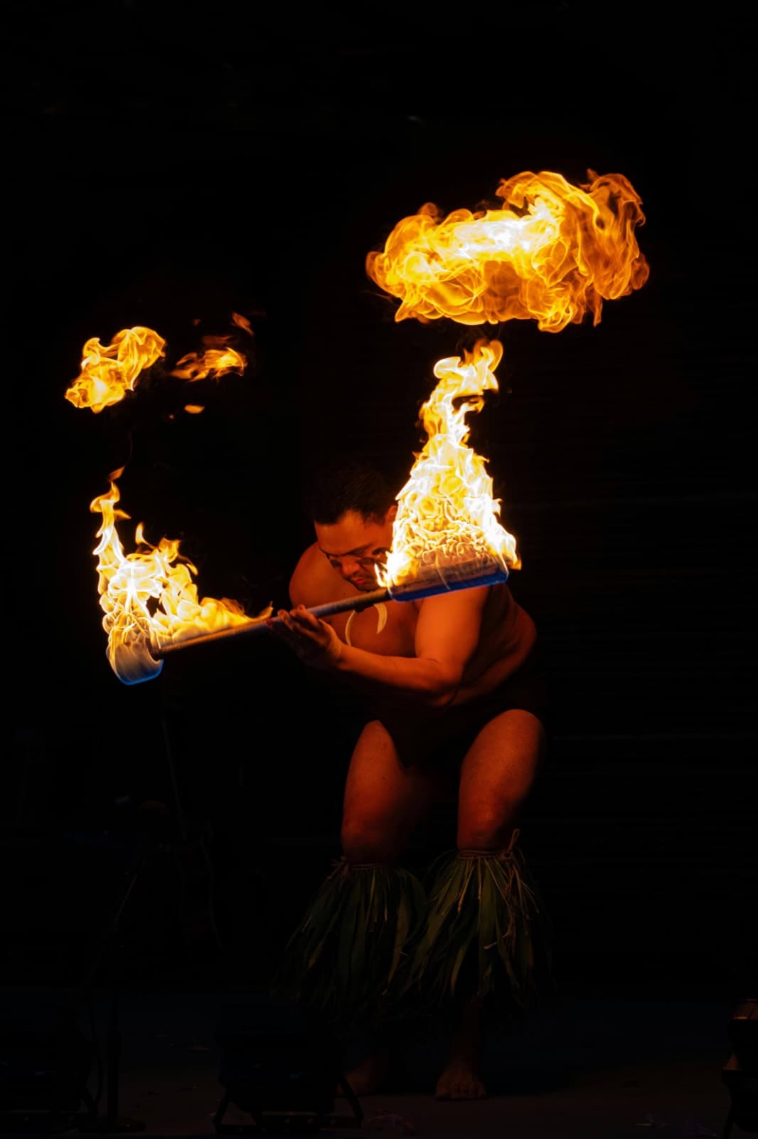 Fire dancer performing at a traditional Hawaiian luau at night