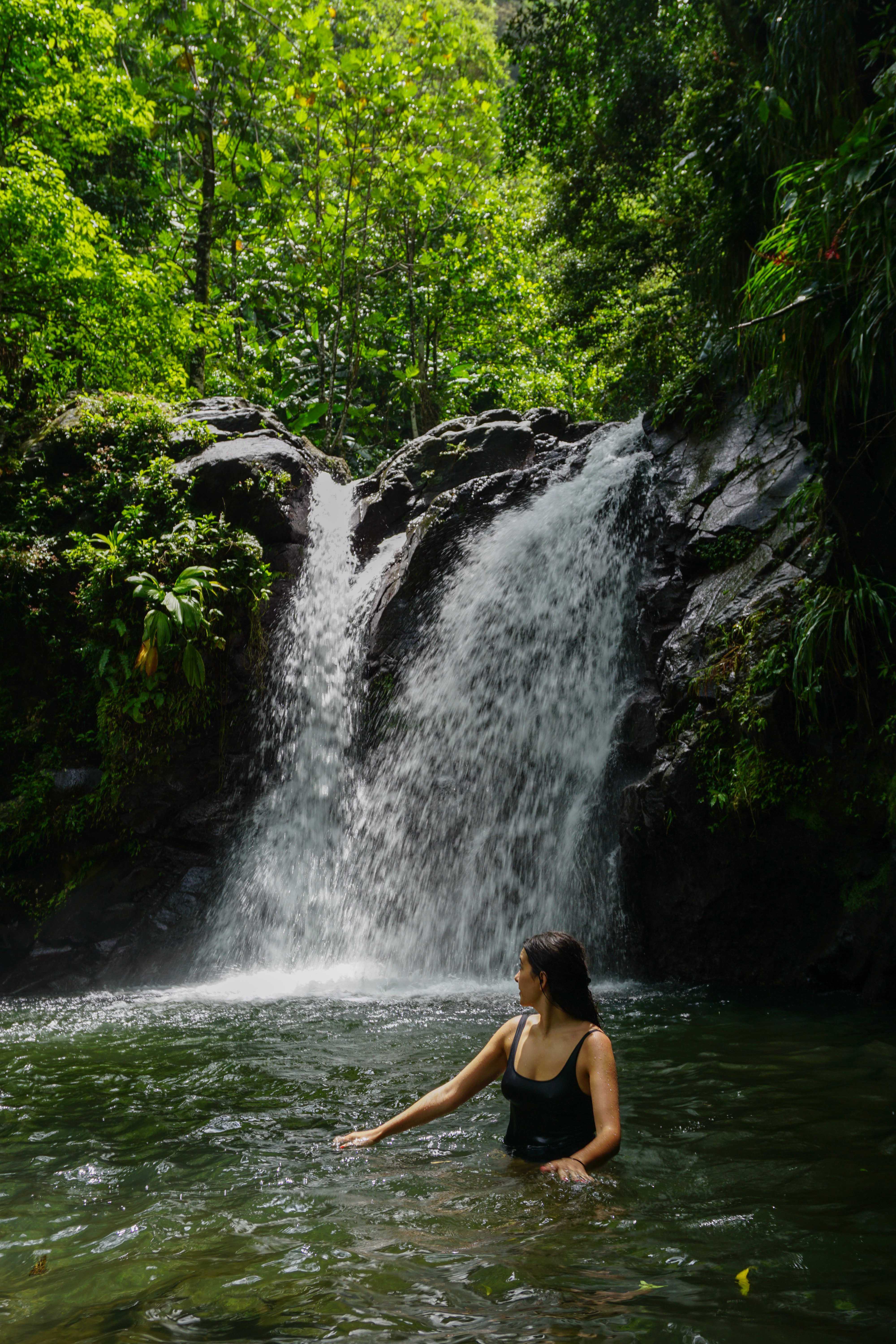Swimming beneath a tropical waterfall