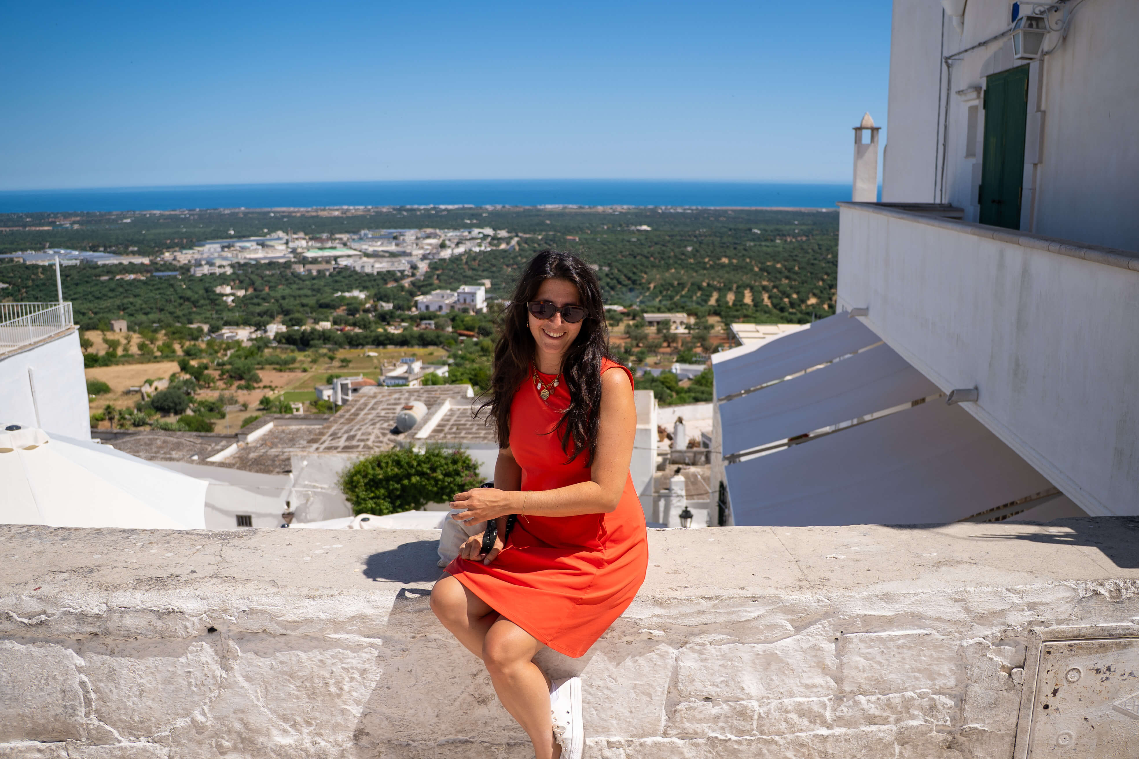 Mailys dans les ruelles blanches d’Ostuni avec la mer au loin