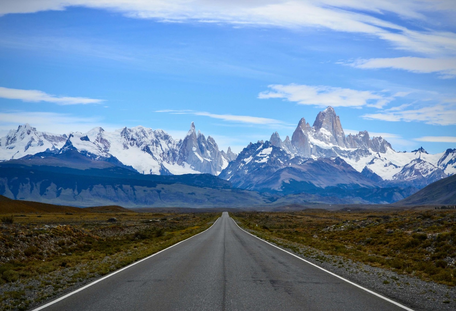 Route rectiligne filant vers les sommets enneigés du massif du Fitz Roy en Patagonie argentine