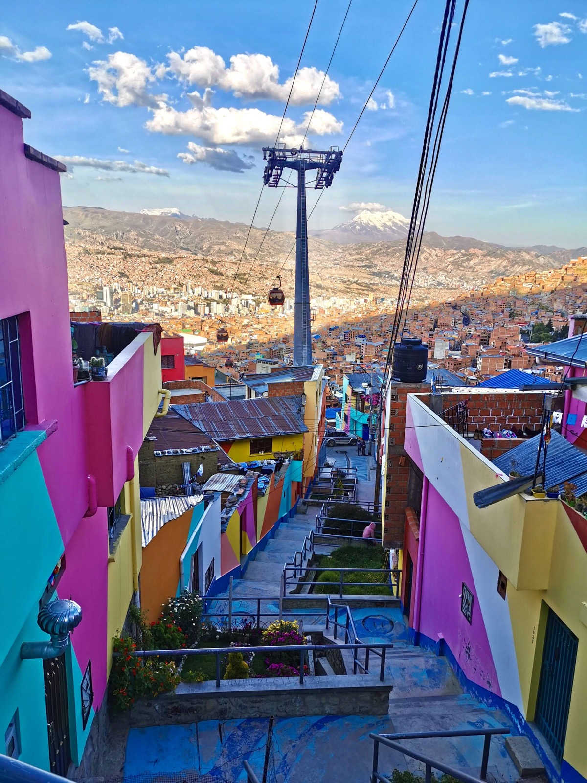 Maisons colorées et téléphérique surplombant La Paz avec une montagne enneigée en arrière-plan